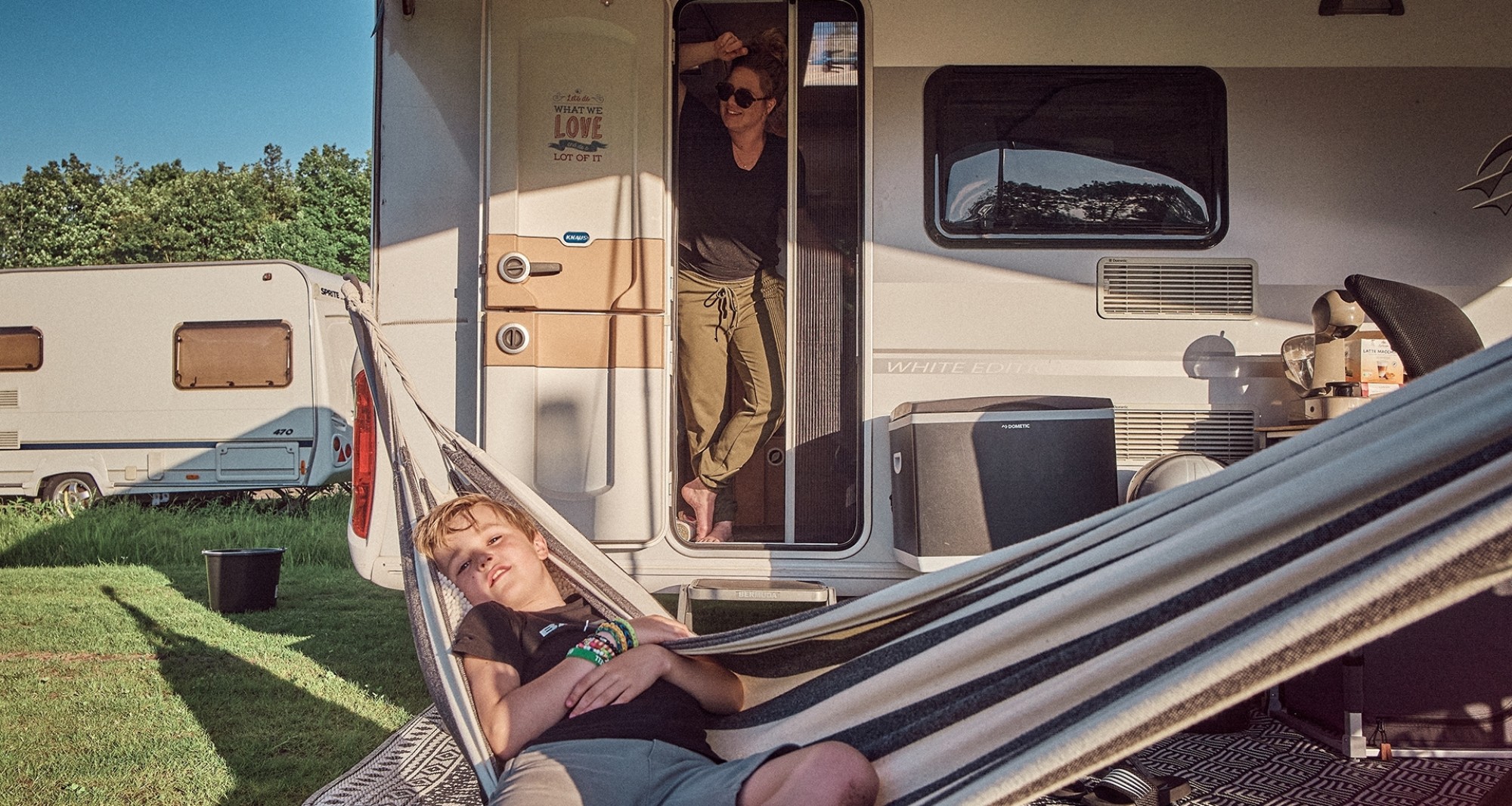 Eine Familie mit Kind entspannt in ihrem Wohnwagen auf dem Gelände von Camperpark Amsterdam